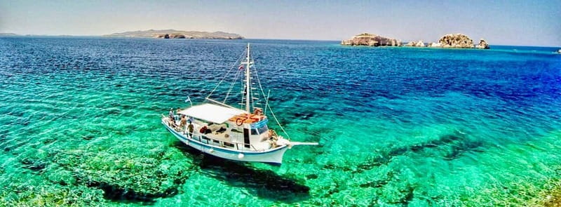 Pounta: Blue Lagoon Boat Tour - San Nikolas Island, clear water, and a small church
