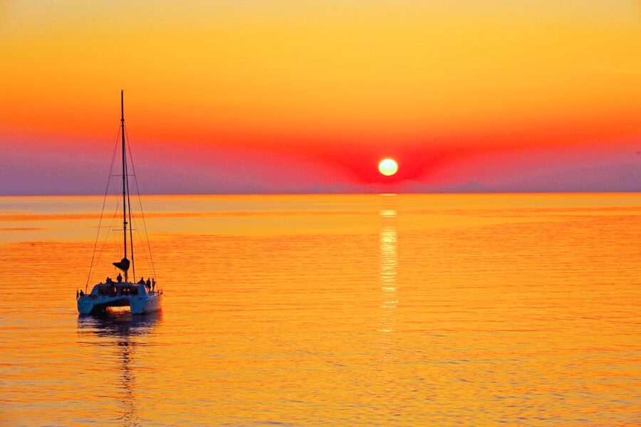 Santorini: Catamaran Tour with BBQ Meal and Unlimited Drinks - The sunset sailing below Oia