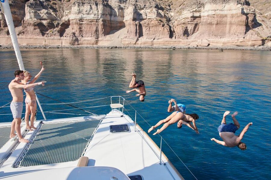 Santorini Gold Catamaran Cruise with Snorkel, BBQ & Open Bar - Leaving Vlychada Marina with wine and mezedes